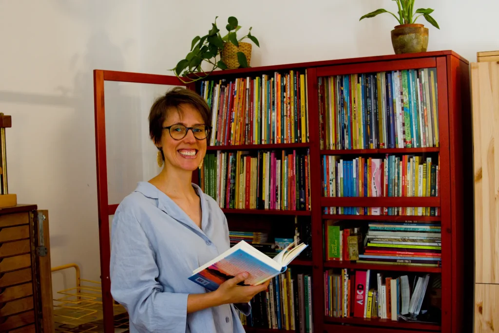 Maria mirant un llibre davant de la biblioteca